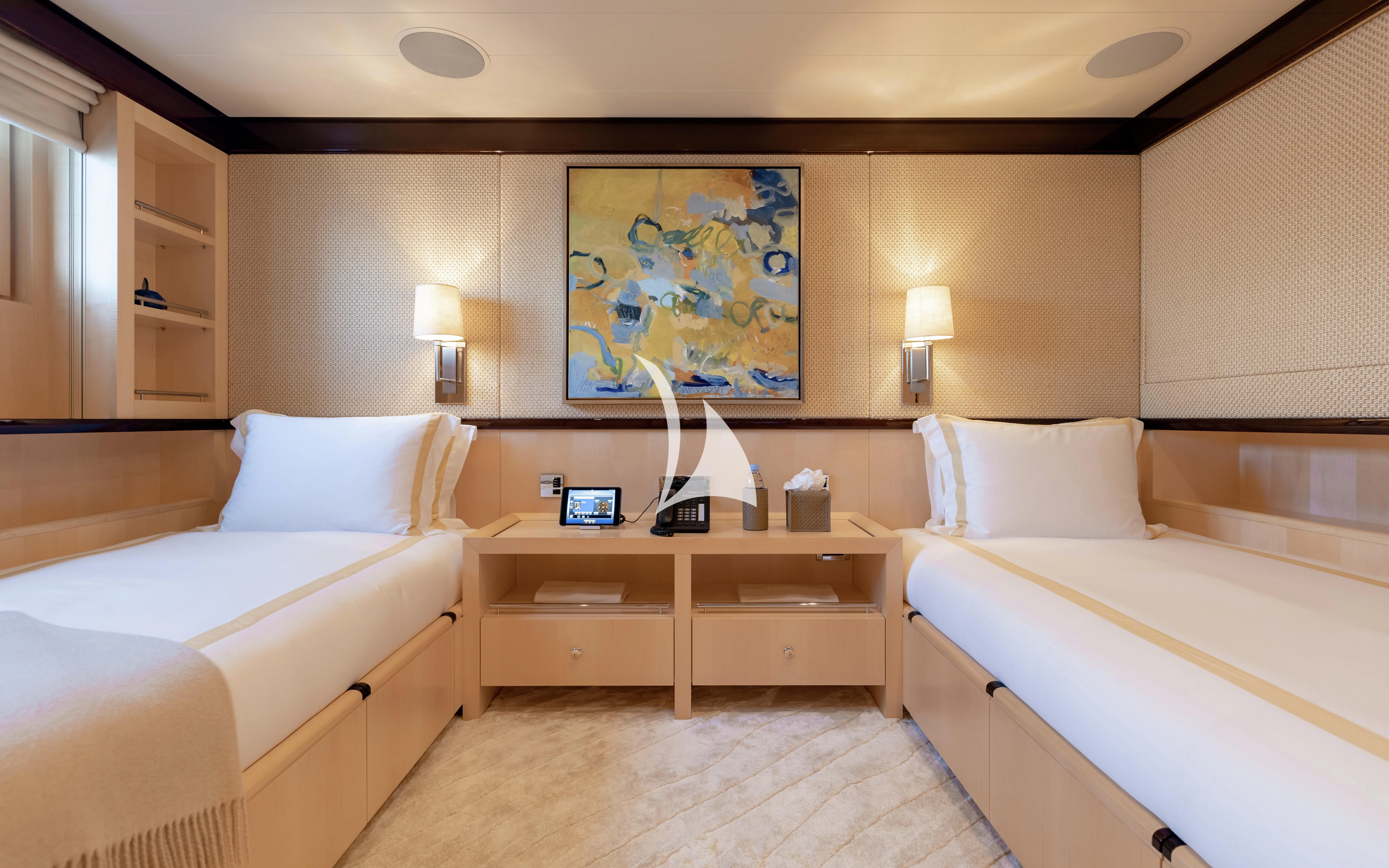a room with two beds and a painting on the wall aboard LA MIRAGE Yacht for Sale