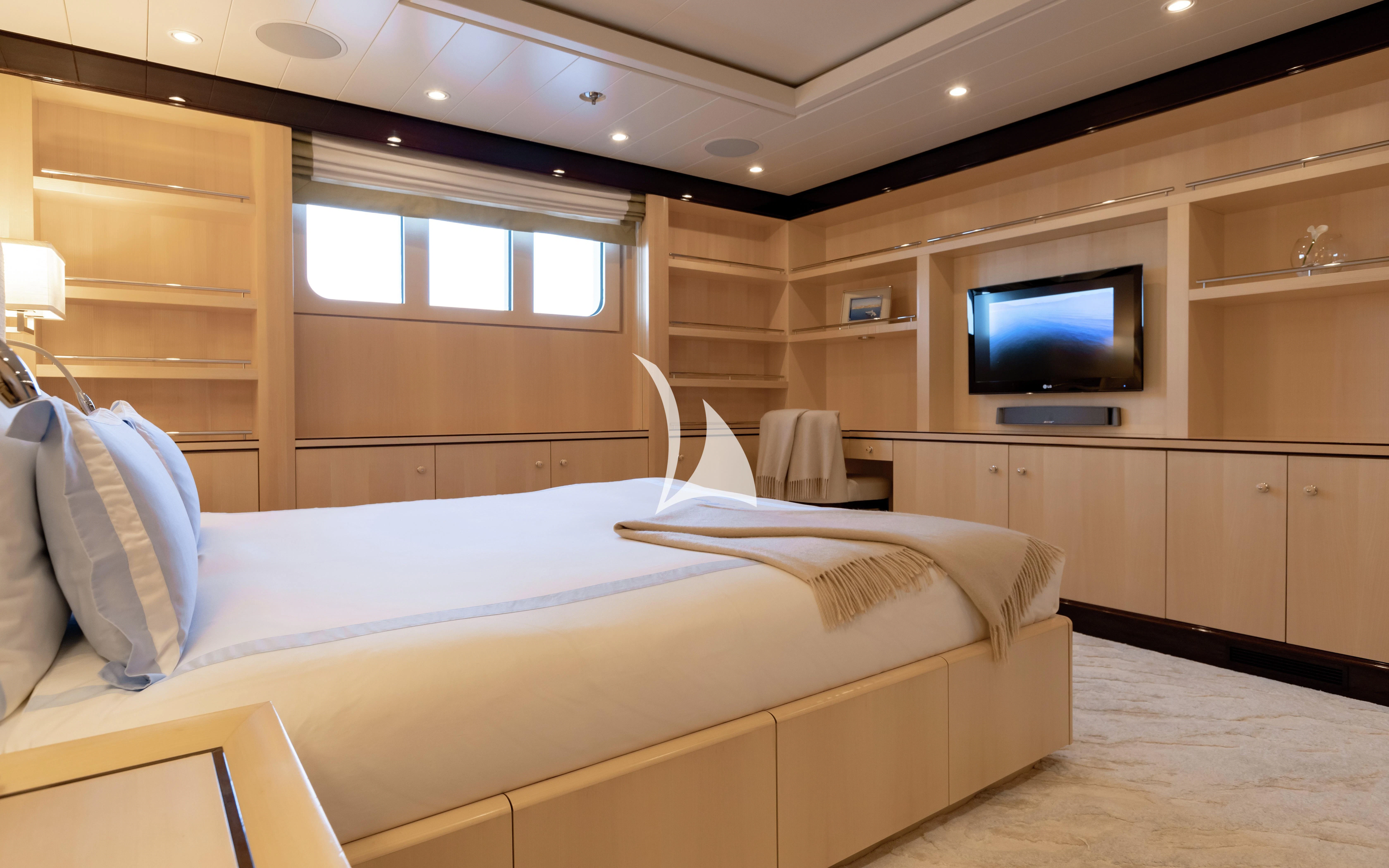 a room with a bed and a television aboard LA MIRAGE Yacht for Sale