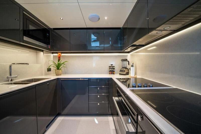 a kitchen with black cabinets aboard IKAL Yacht for Sale