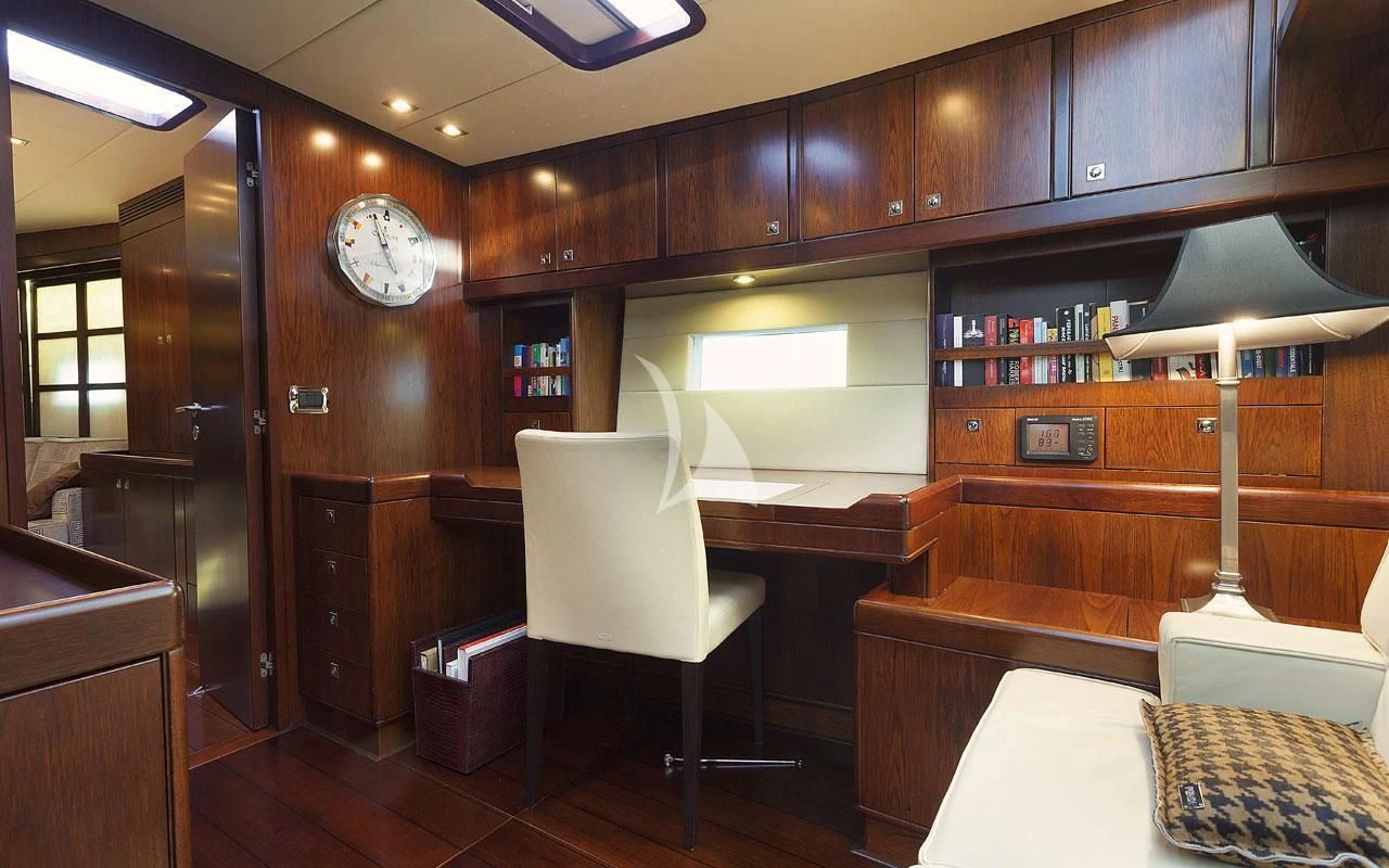 a room with a chair and a clock on the wall aboard FAR AND WIDE Yacht for Sale