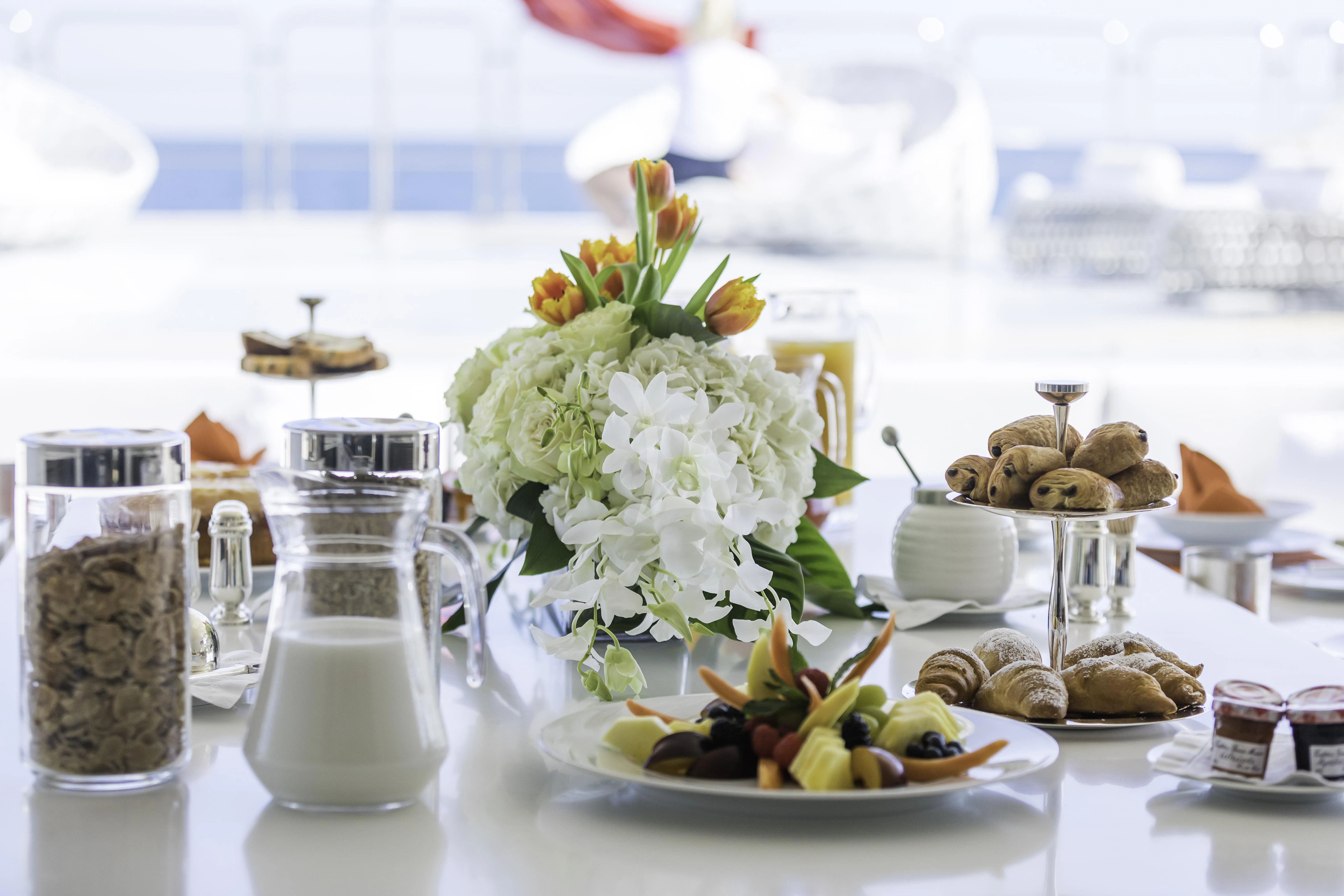 a table with food and a vase of flowers aboard VICKY Yacht for Charter