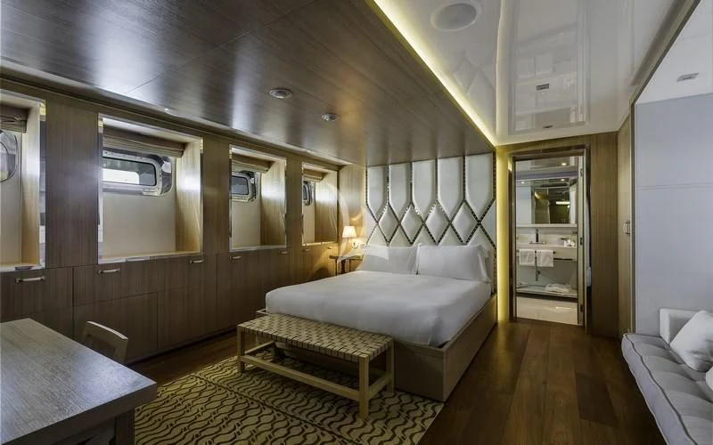 a room with a bed and a table aboard VICKY Yacht for Charter