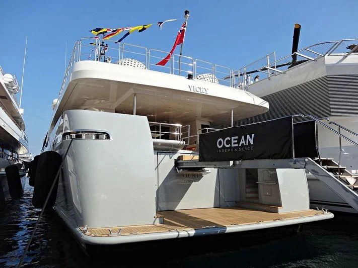 a large white boat with a flag on top aboard VICKY Yacht for Charter