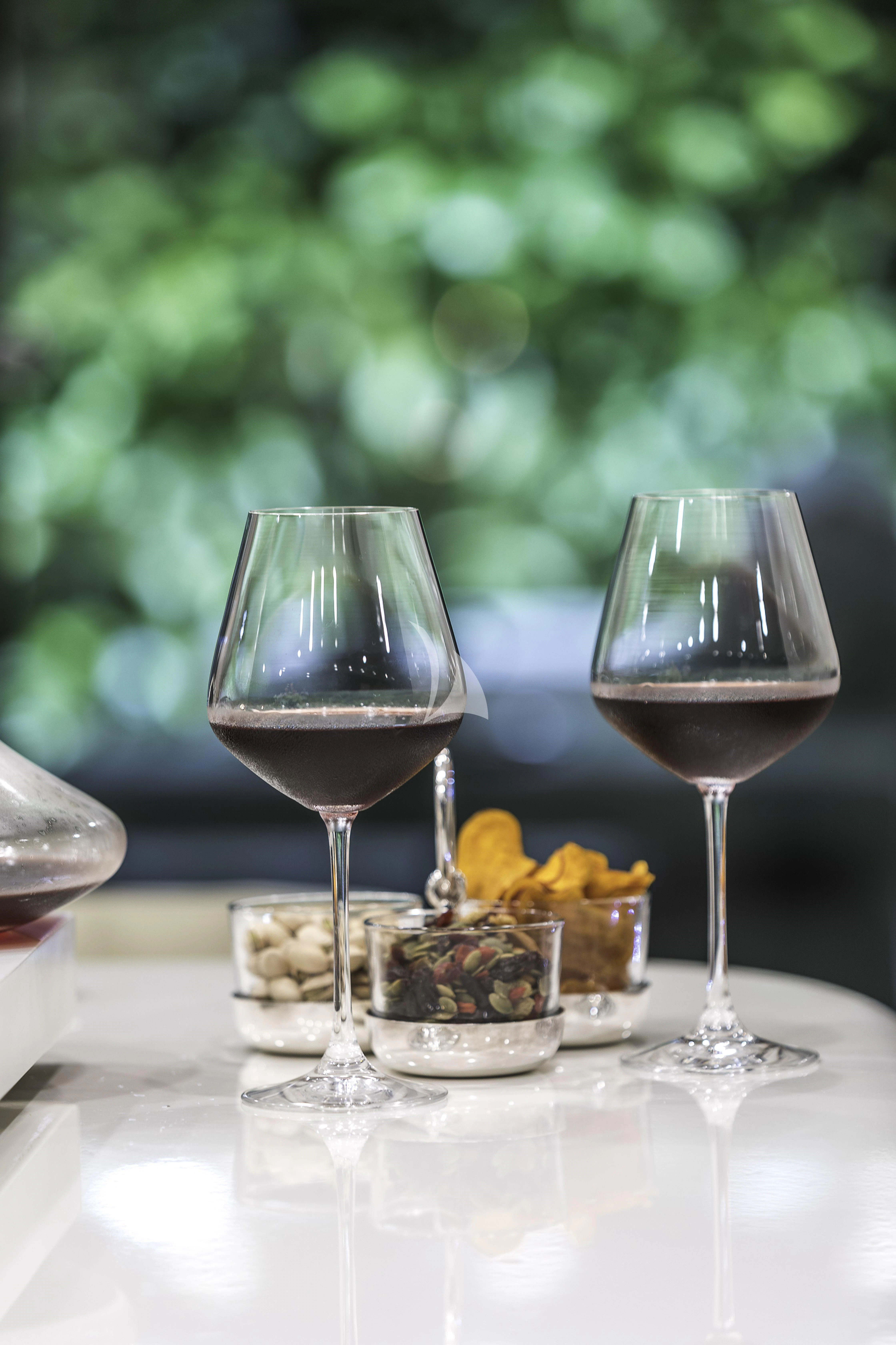 a glass of wine and a bowl of fruit on a table aboard VICKY Yacht for Charter