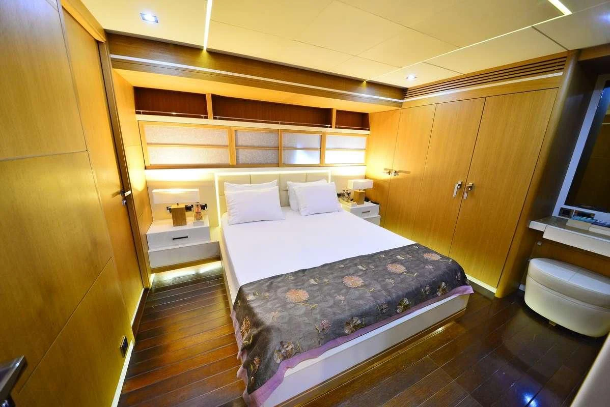 a room with a bed and a dresser aboard ZELDA Yacht for Sale