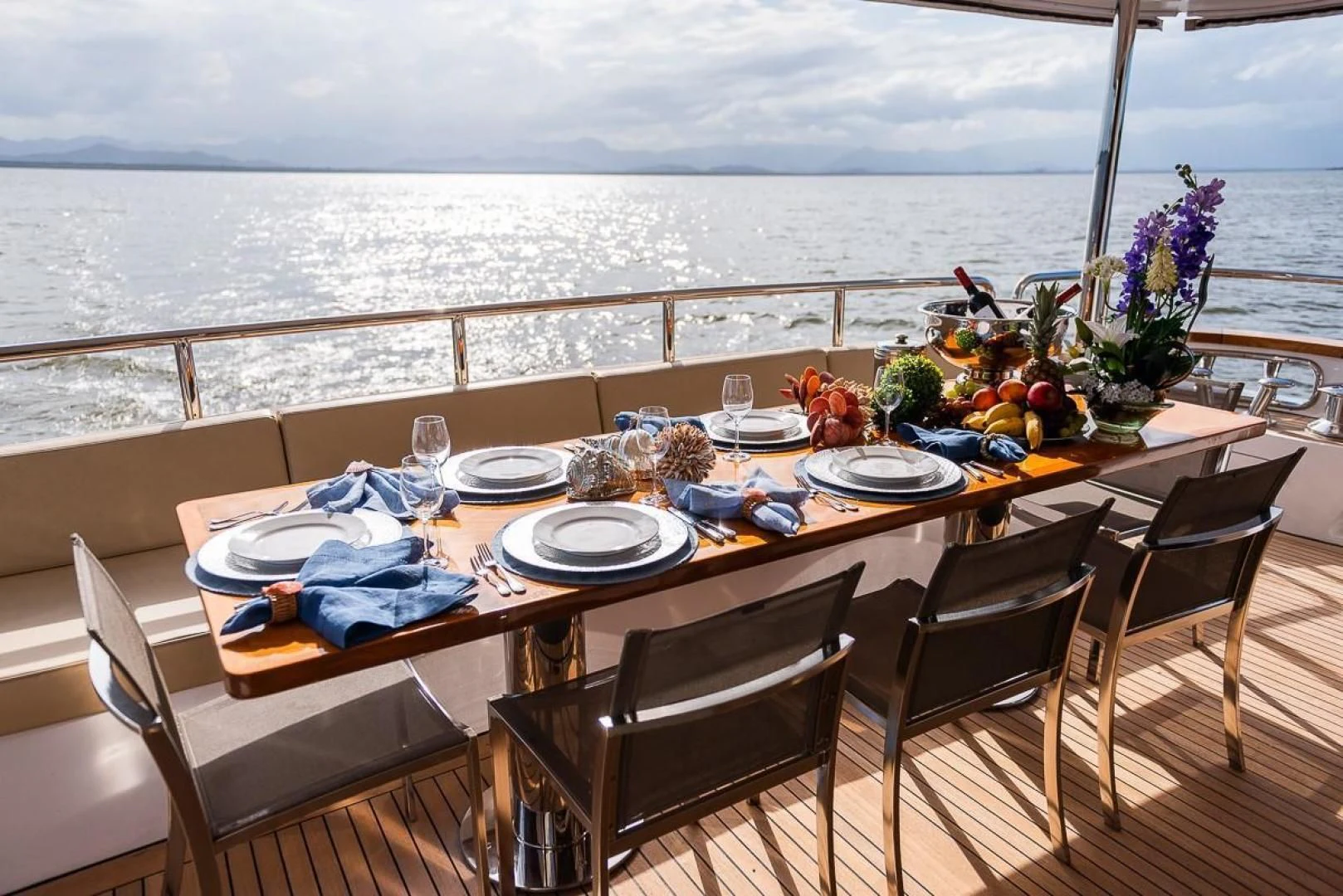 a table set for a meal on a balcony overlooking the ocean aboard BLUE BAY Yacht for Sale
