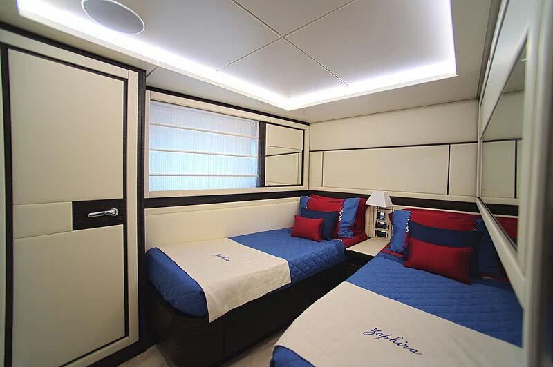 a room with beds and a door aboard BLUE BAY Yacht for Sale