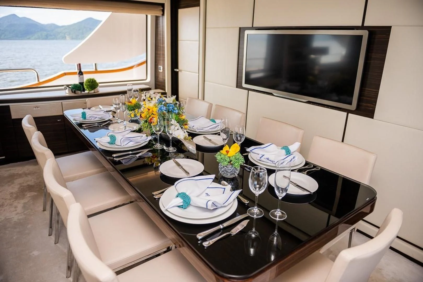 a dining table with plates and glasses aboard BLUE BAY Yacht for Sale