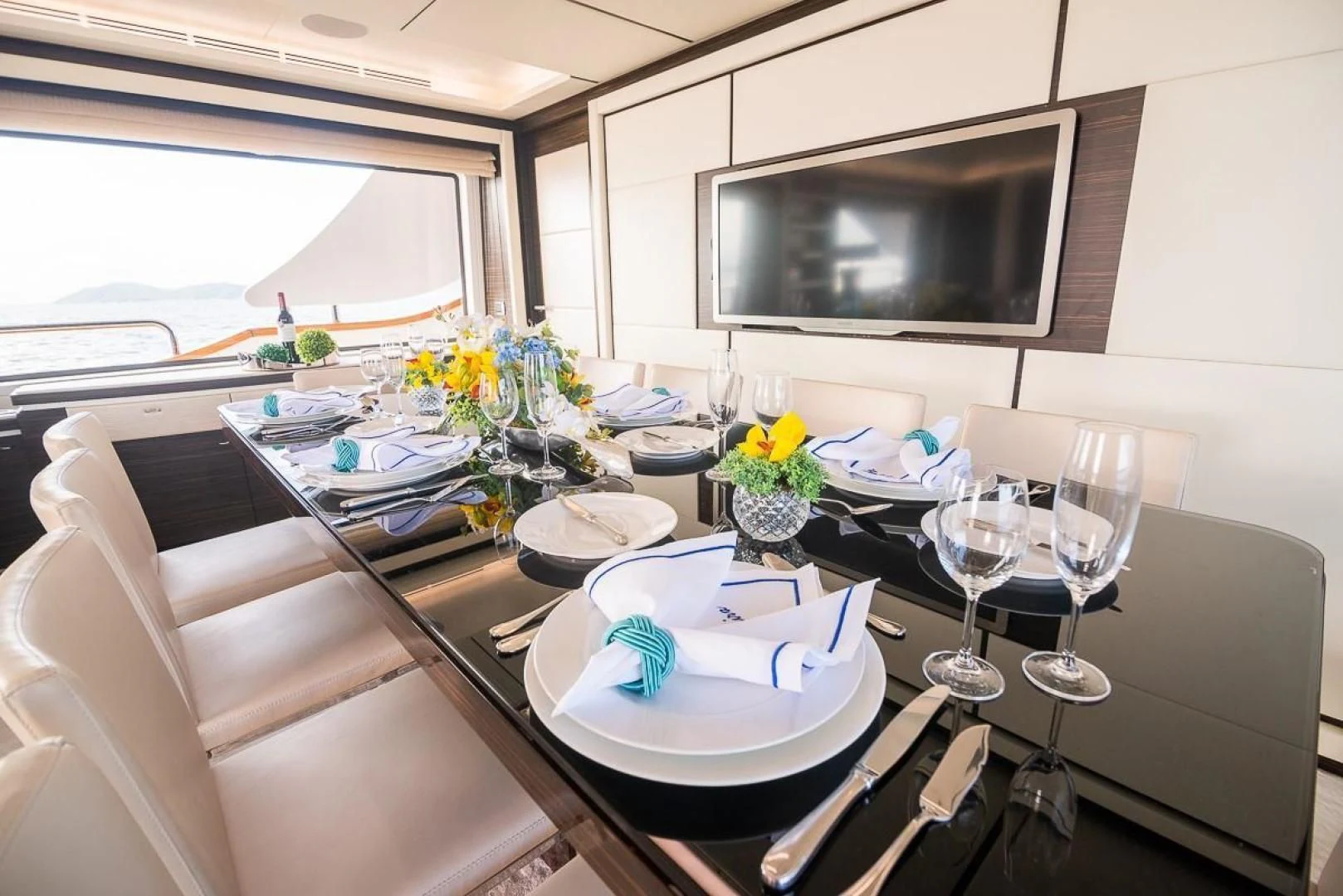 a dining table with plates and glasses aboard BLUE BAY Yacht for Sale