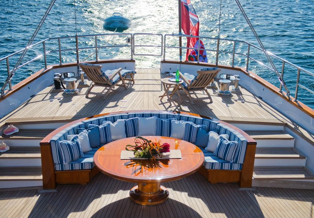 a deck with a table and chairs on it aboard MORNING GLORY Yacht for Sale