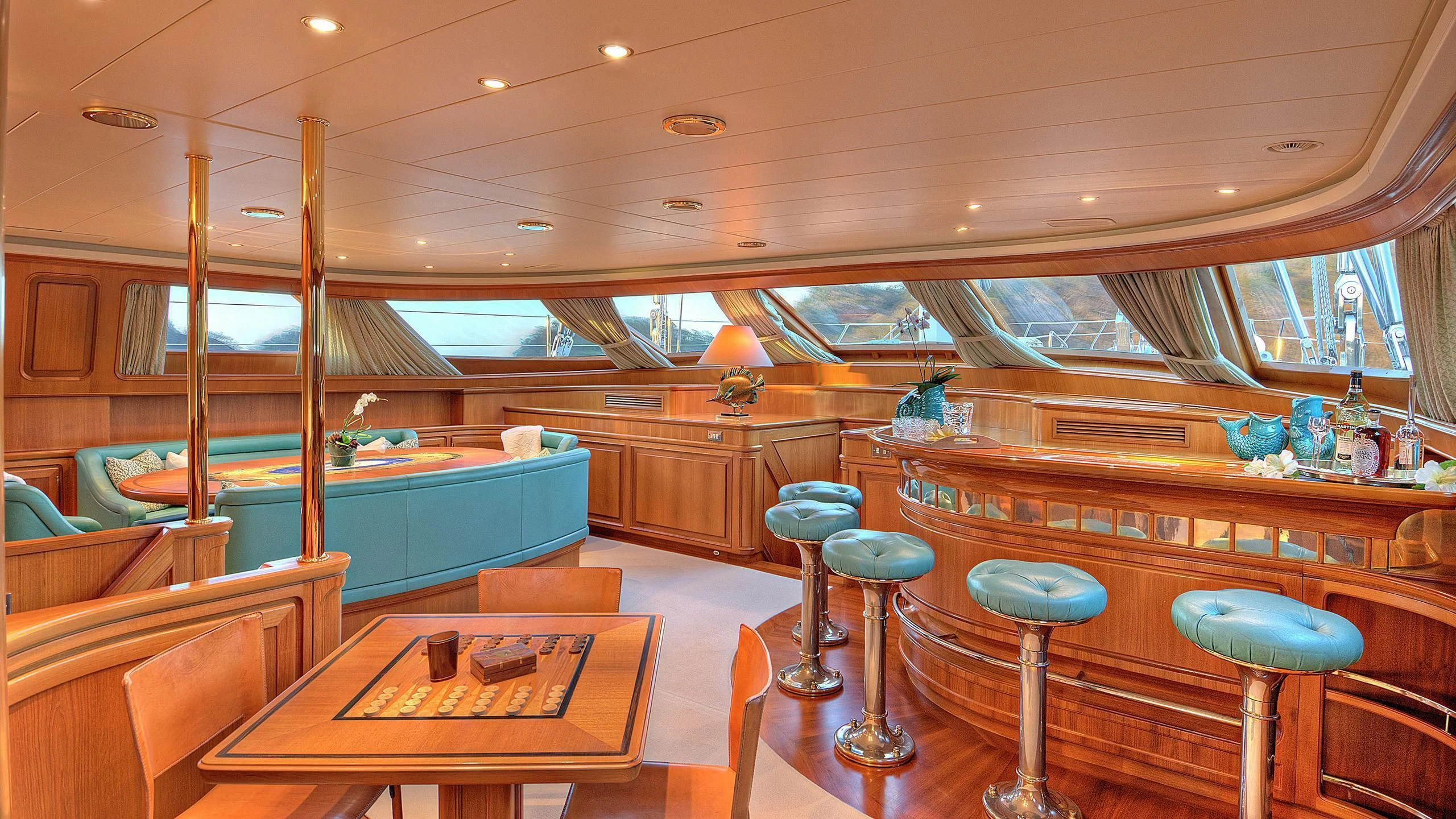 a room with a table and stools and a bar aboard MORNING GLORY Yacht for Sale