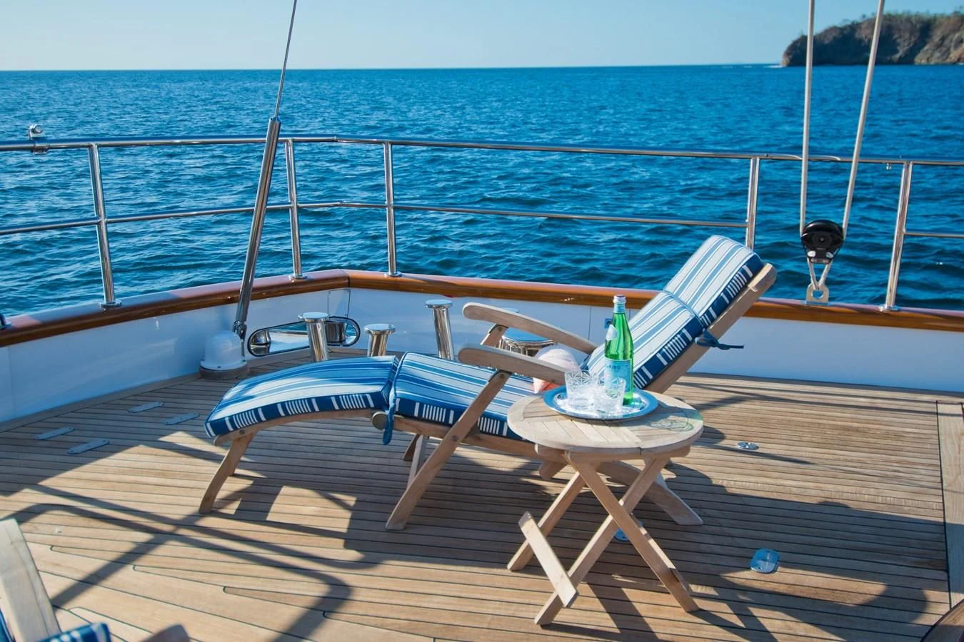 a glass bottle on a table on a beach aboard MORNING GLORY Yacht for Sale