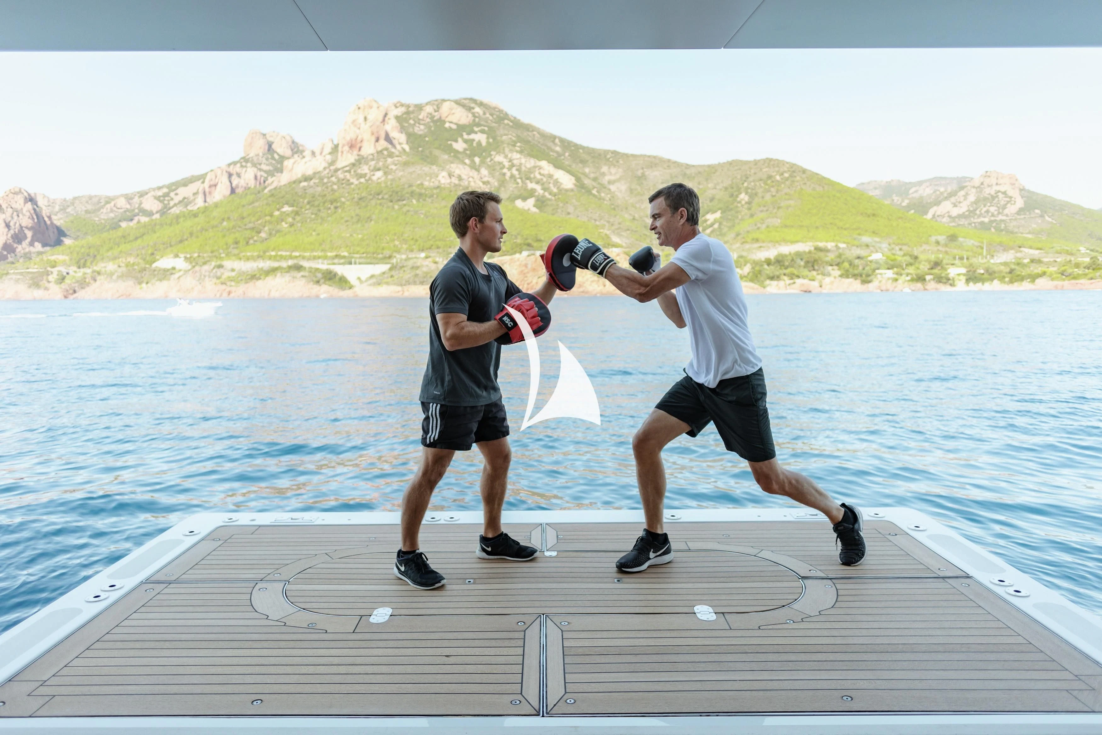 a man holding a camera and a man standing on a dock by a body of water aboard SEANNA Yacht for Sale