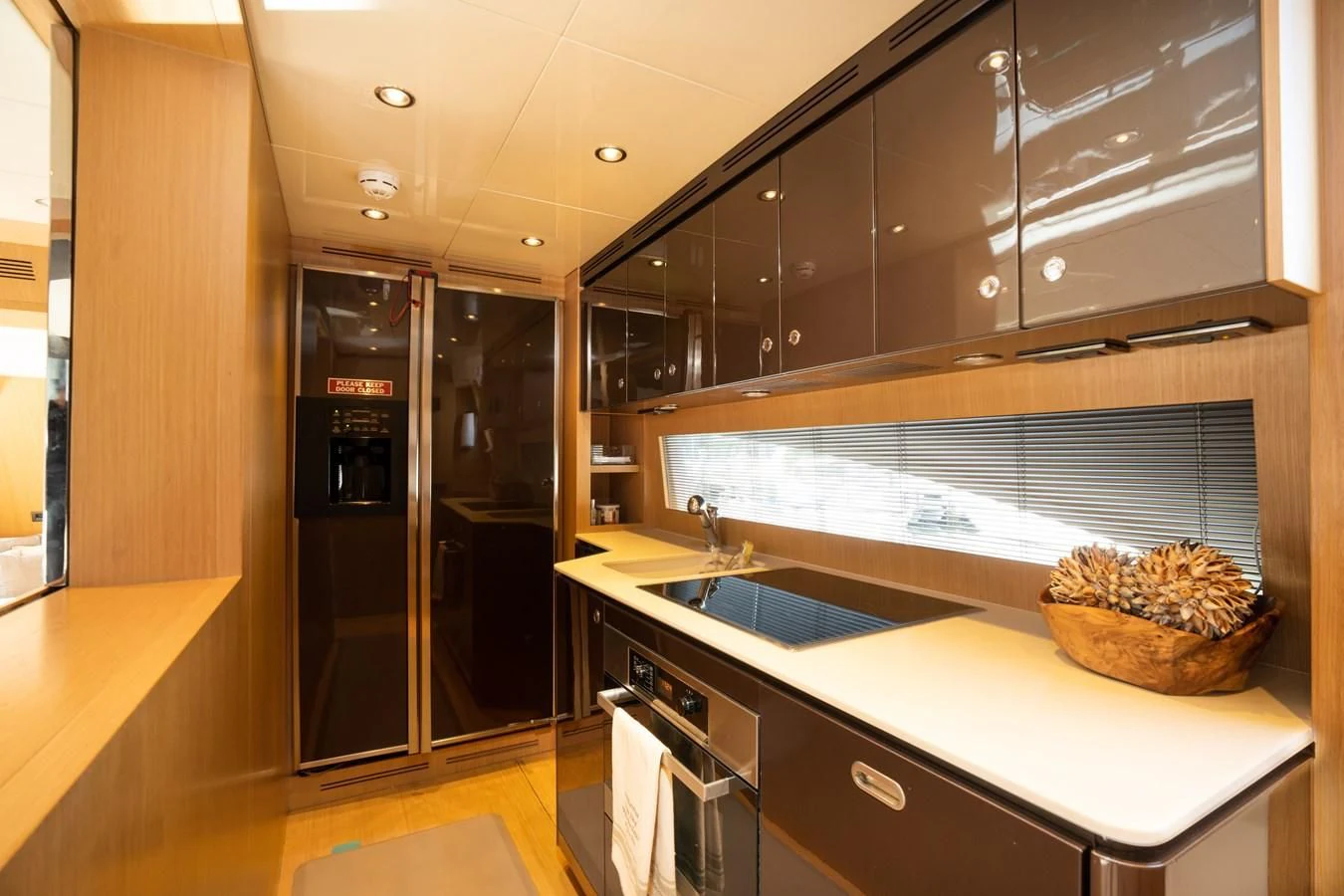 a kitchen with black cabinets aboard 75' RIVA 2012 Yacht for Sale