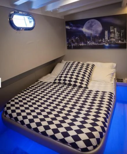 a bed with a checkered blanket aboard LA MER Yacht for Sale