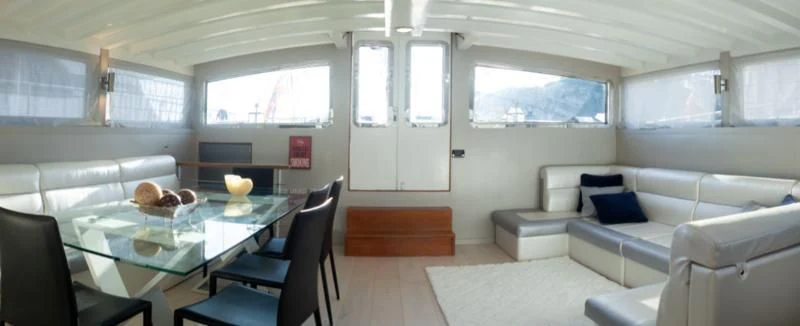 a room with a table and chairs aboard LA MER Yacht for Sale