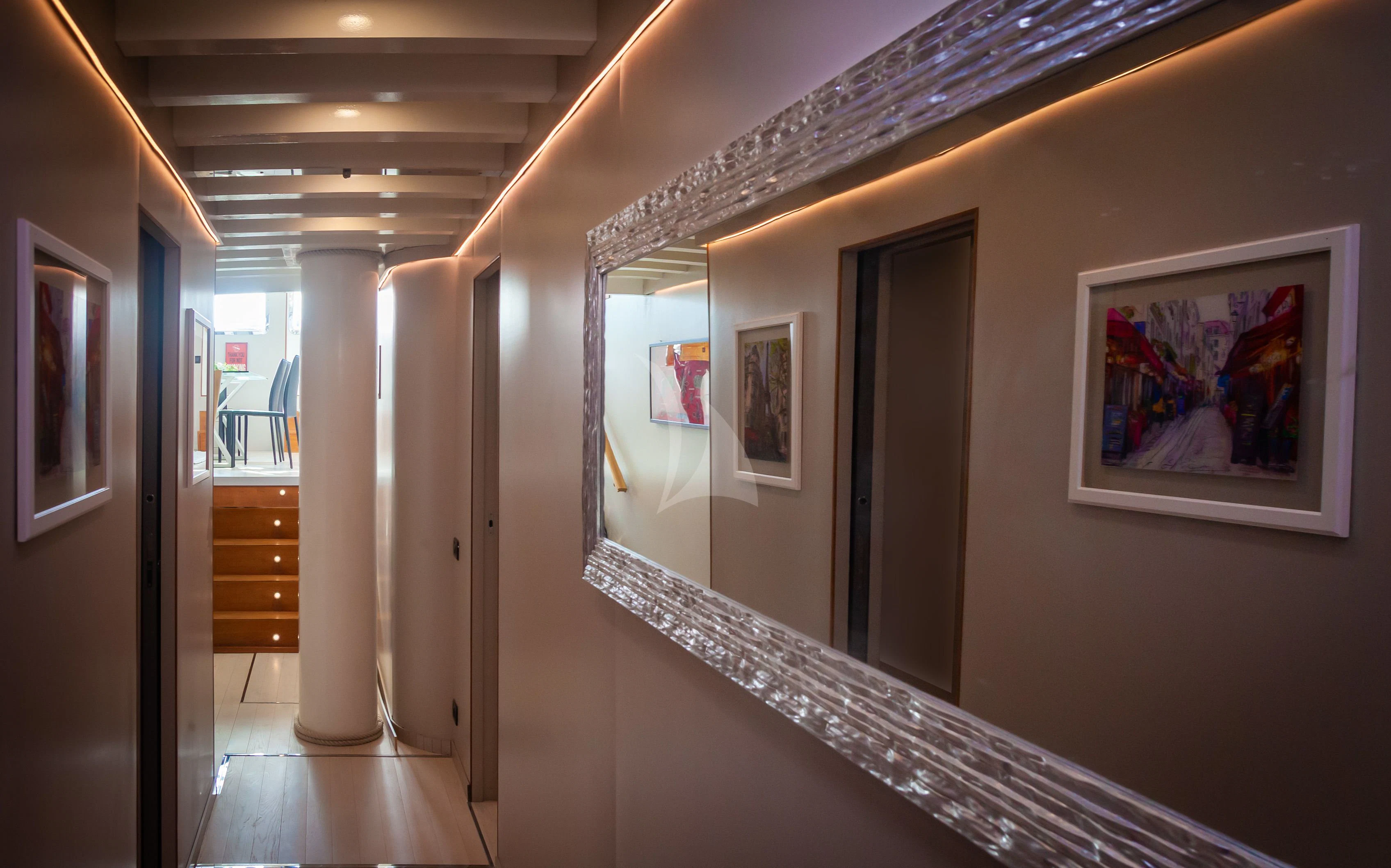 a hallway with paintings on the wall aboard LA MER Yacht for Sale