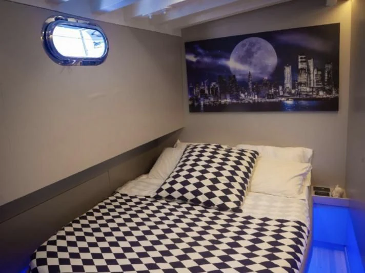 a bed with a black and white checkered blanket aboard LA MER Yacht for Sale