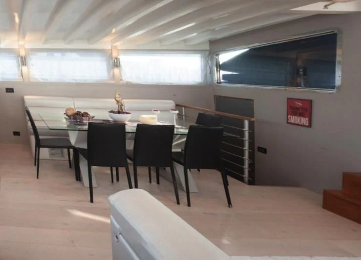 a room with a table and chairs aboard LA MER Yacht for Sale