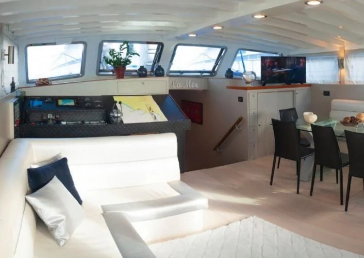 a room with a couch and a television aboard LA MER Yacht for Sale