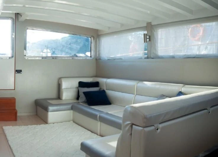 a room with a couch and a window aboard LA MER Yacht for Sale