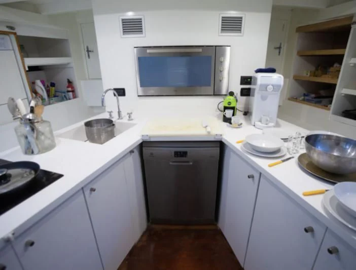 a kitchen with white cabinets aboard LA MER Yacht for Sale