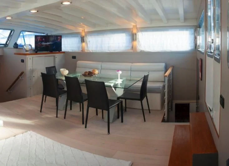 a table with chairs around it aboard LA MER Yacht for Sale