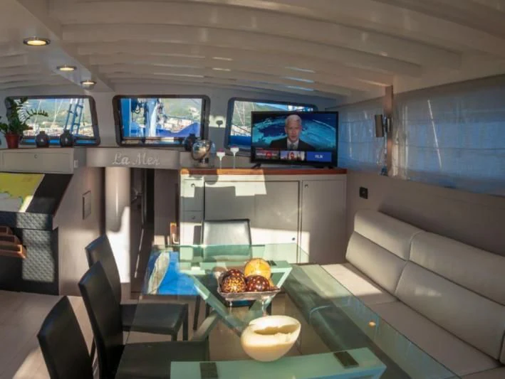 a room with a tv and a table with food on it aboard LA MER Yacht for Sale