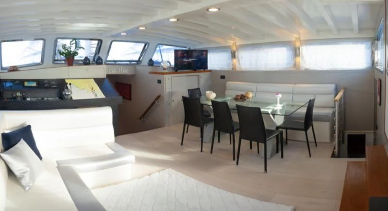 a room with a table and chairs aboard LA MER Yacht for Sale