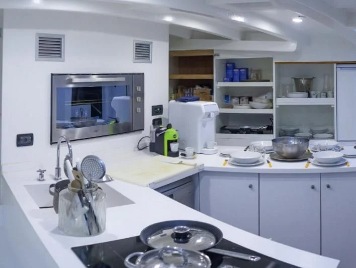 a kitchen with a sink and a television aboard LA MER Yacht for Sale