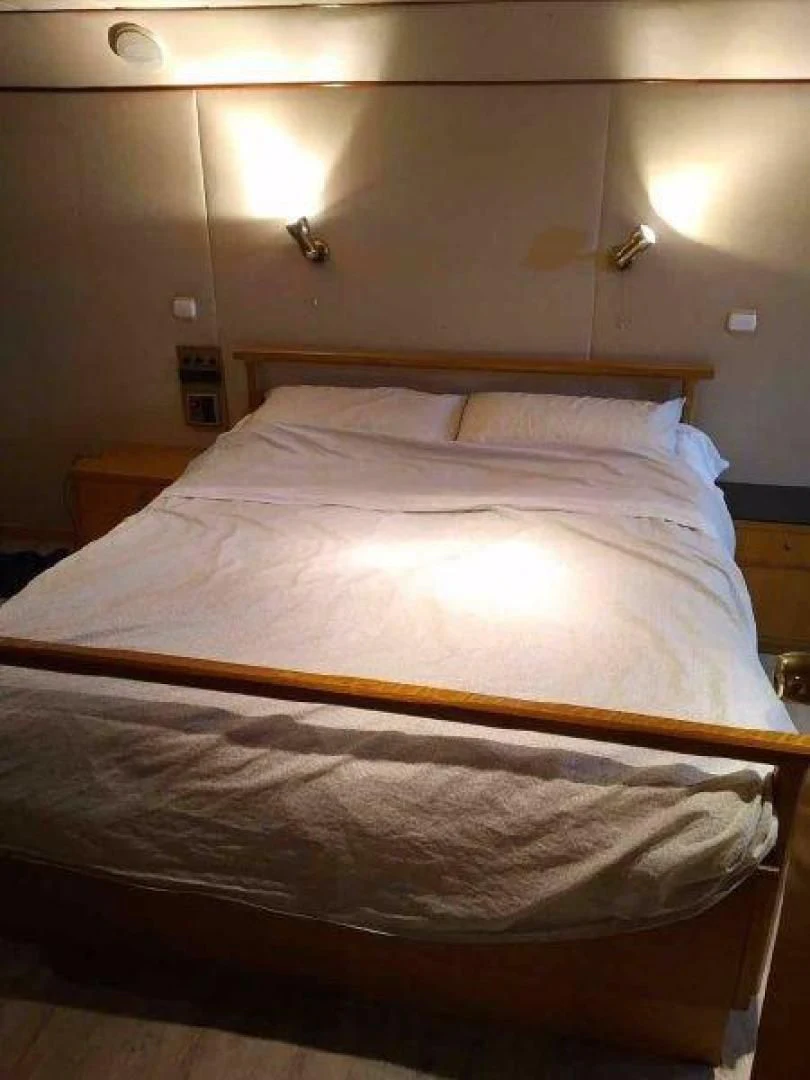 a bed with a white comforter aboard STAR ALLIANCE Yacht for Sale