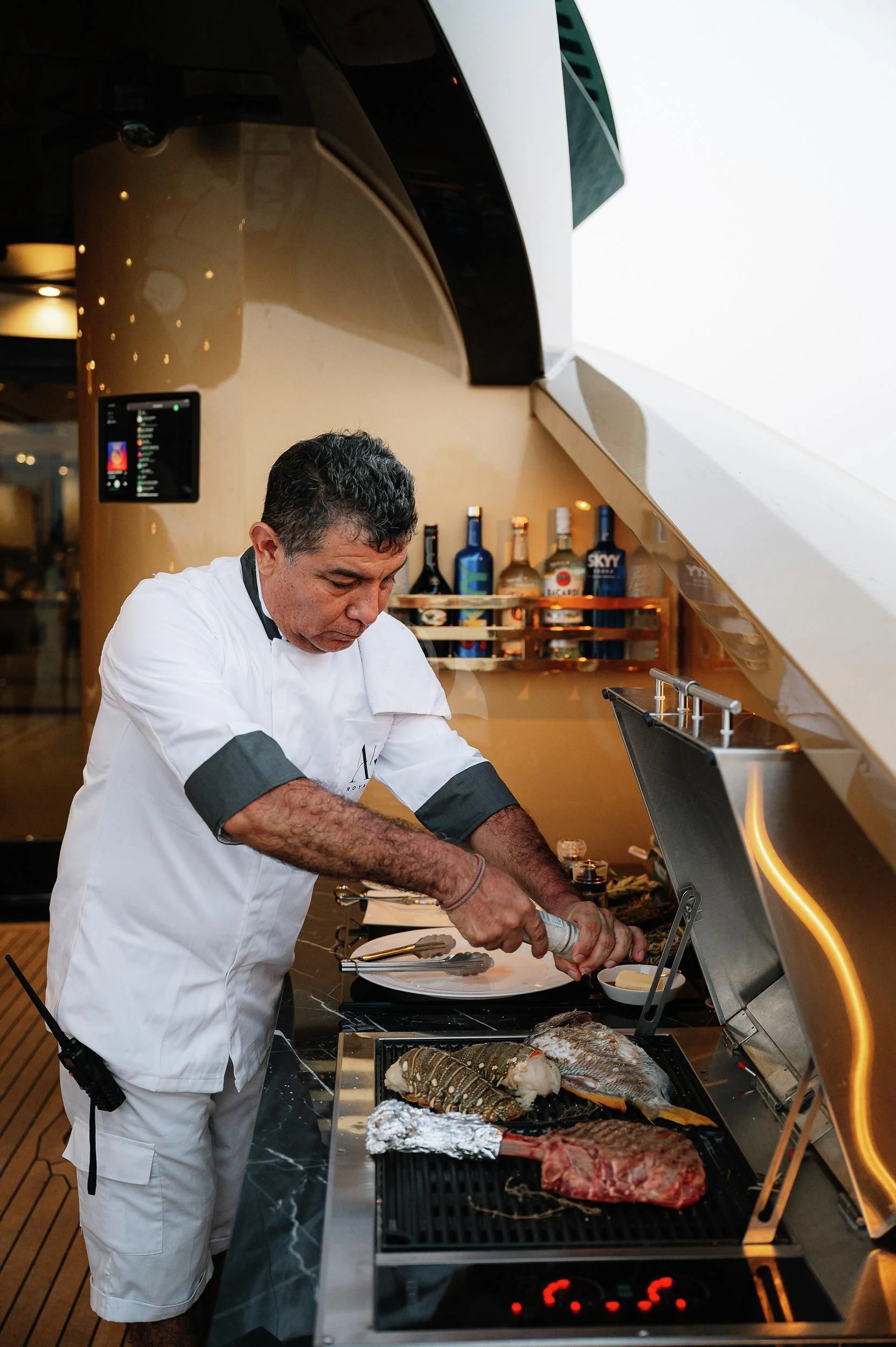 a man preparing food in a kitchen aboard AK ROYALTY Yacht for Sale