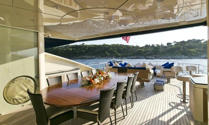 a table set for a meal on a balcony overlooking a body of water aboard AK ROYALTY Yacht for Sale