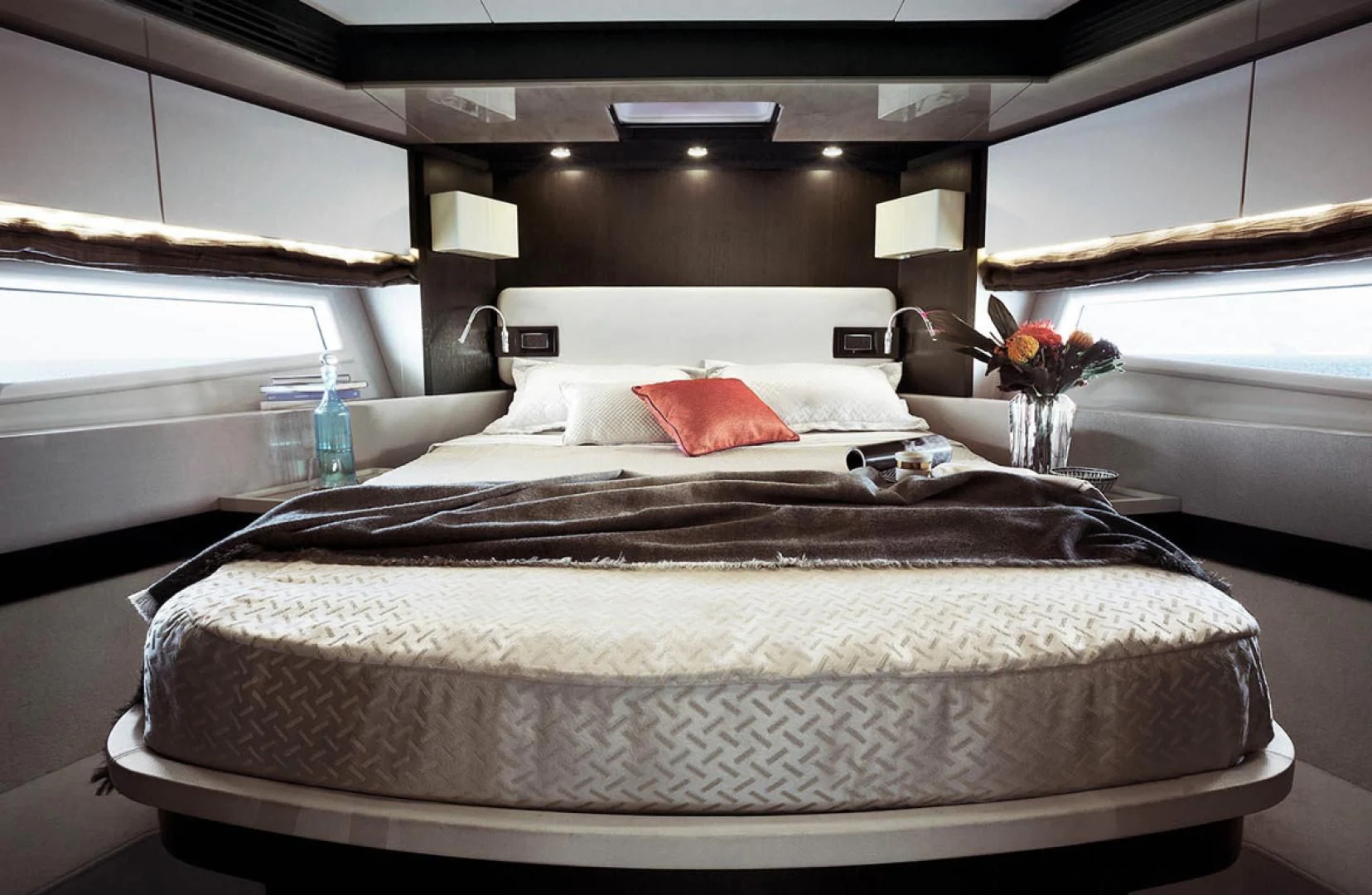 a bed with a white cover and red pillows aboard CERULEAN Yacht for Sale