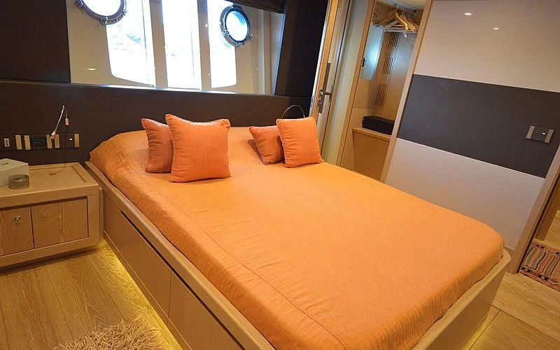a bed with orange pillows aboard DISPARATE Yacht for Sale