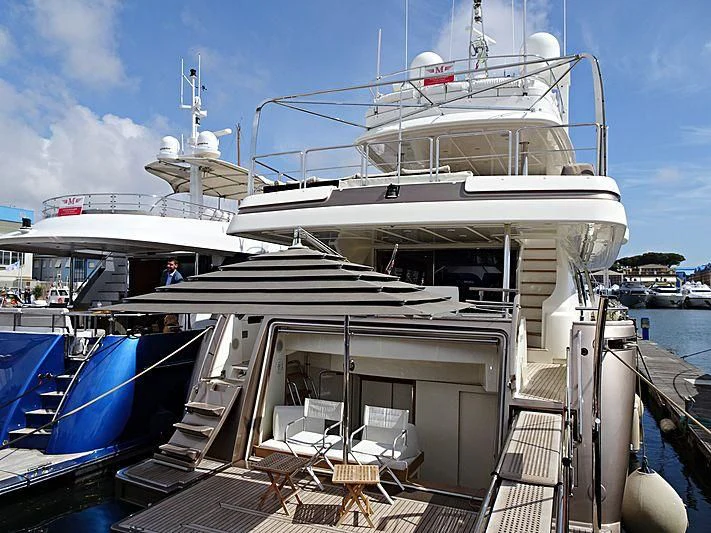 a large white boat with chairs on a dock aboard DISPARATE Yacht for Sale