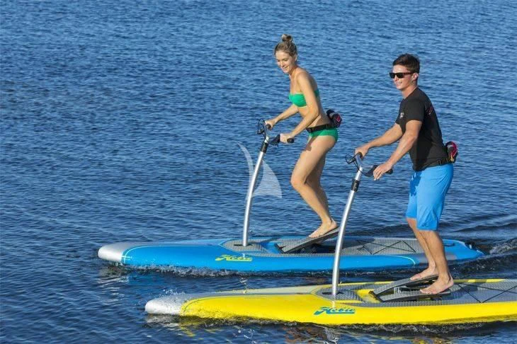 a man and woman on a paddle board aboard DISPARATE Yacht for Sale