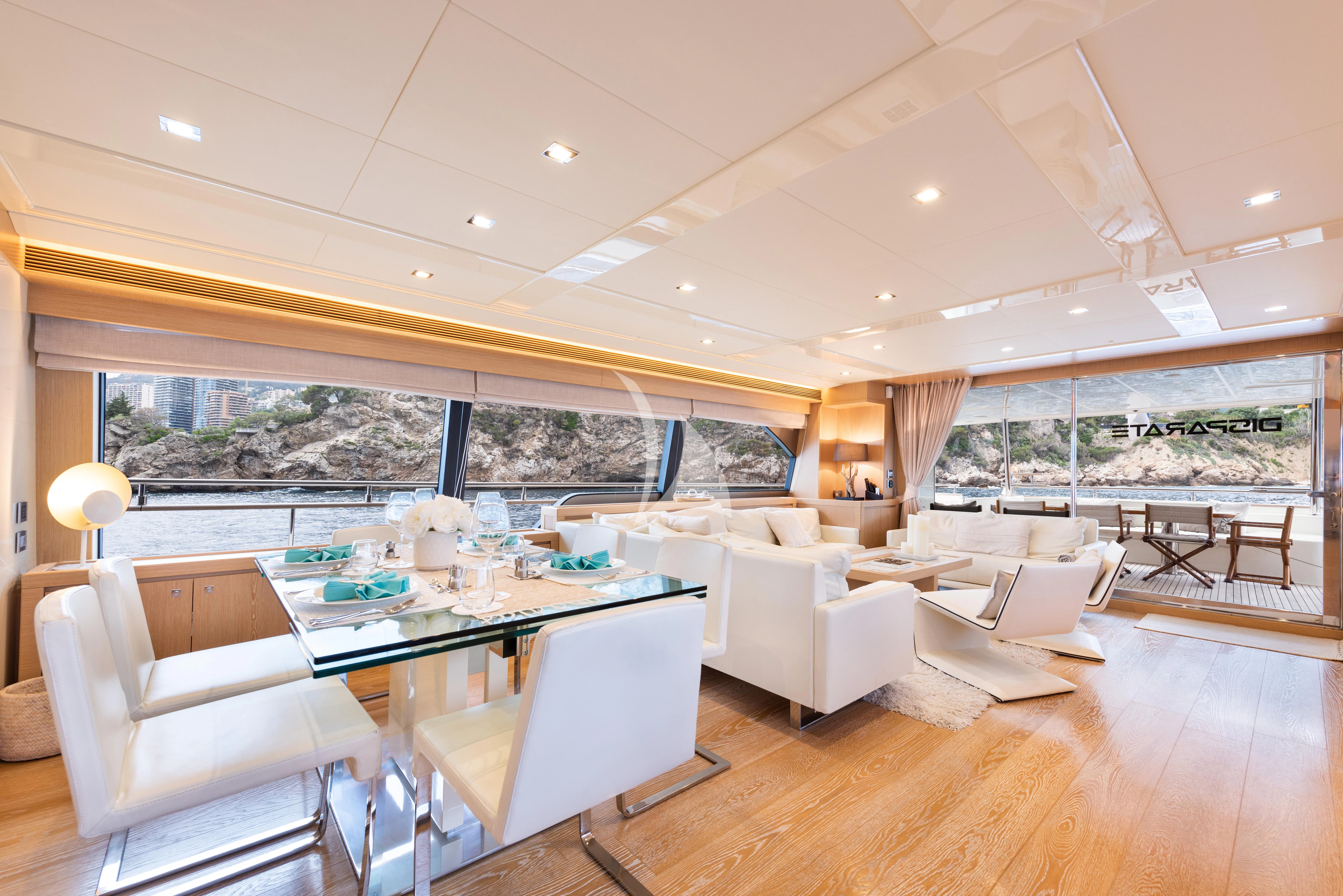 a large living room with a large table and chairs aboard DISPARATE Yacht for Sale