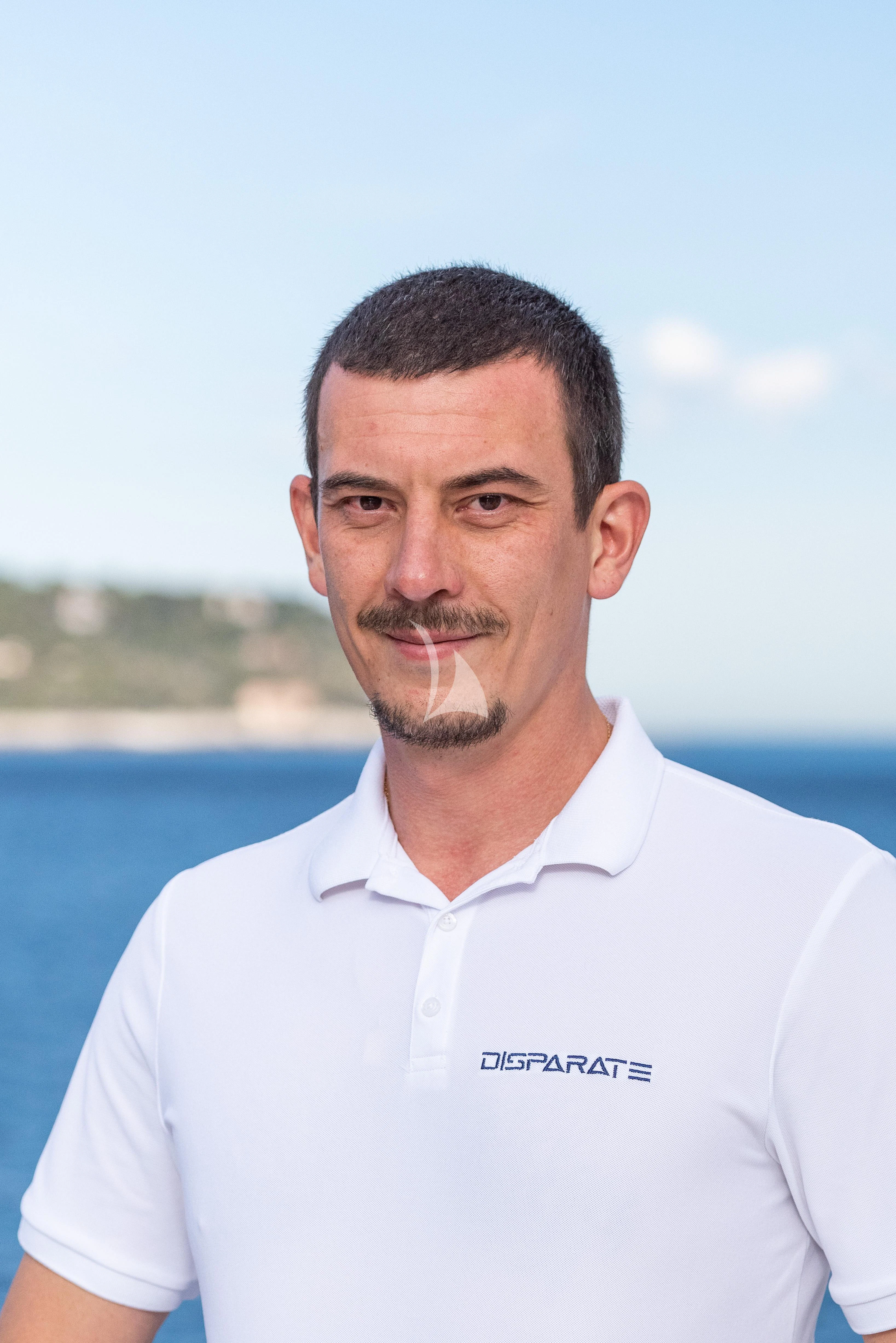 a man smiling for the picture aboard DISPARATE Yacht for Sale
