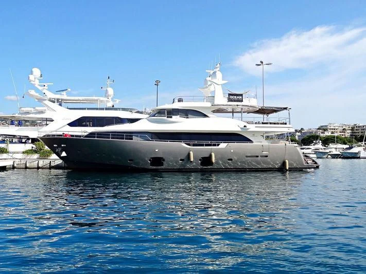 a large white boat in a harbor aboard DISPARATE Yacht for Sale