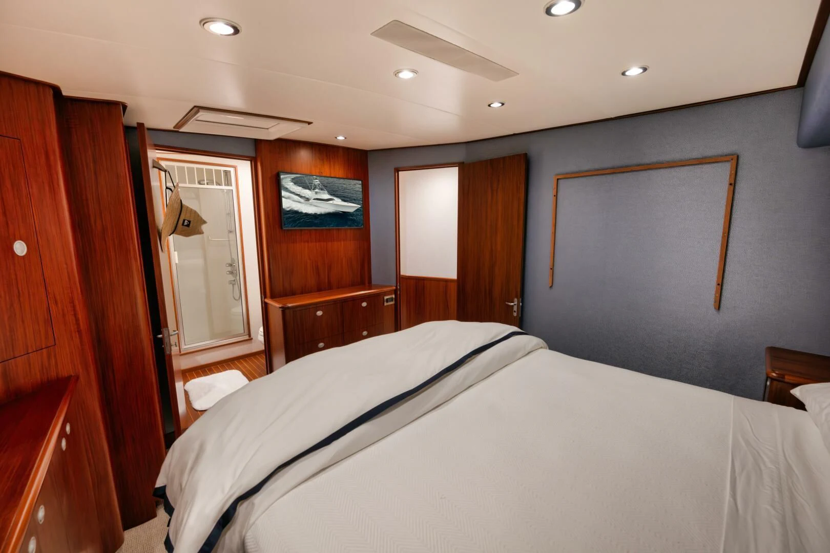 a bedroom with a bed and a wood cabinet aboard W Yacht for Sale
