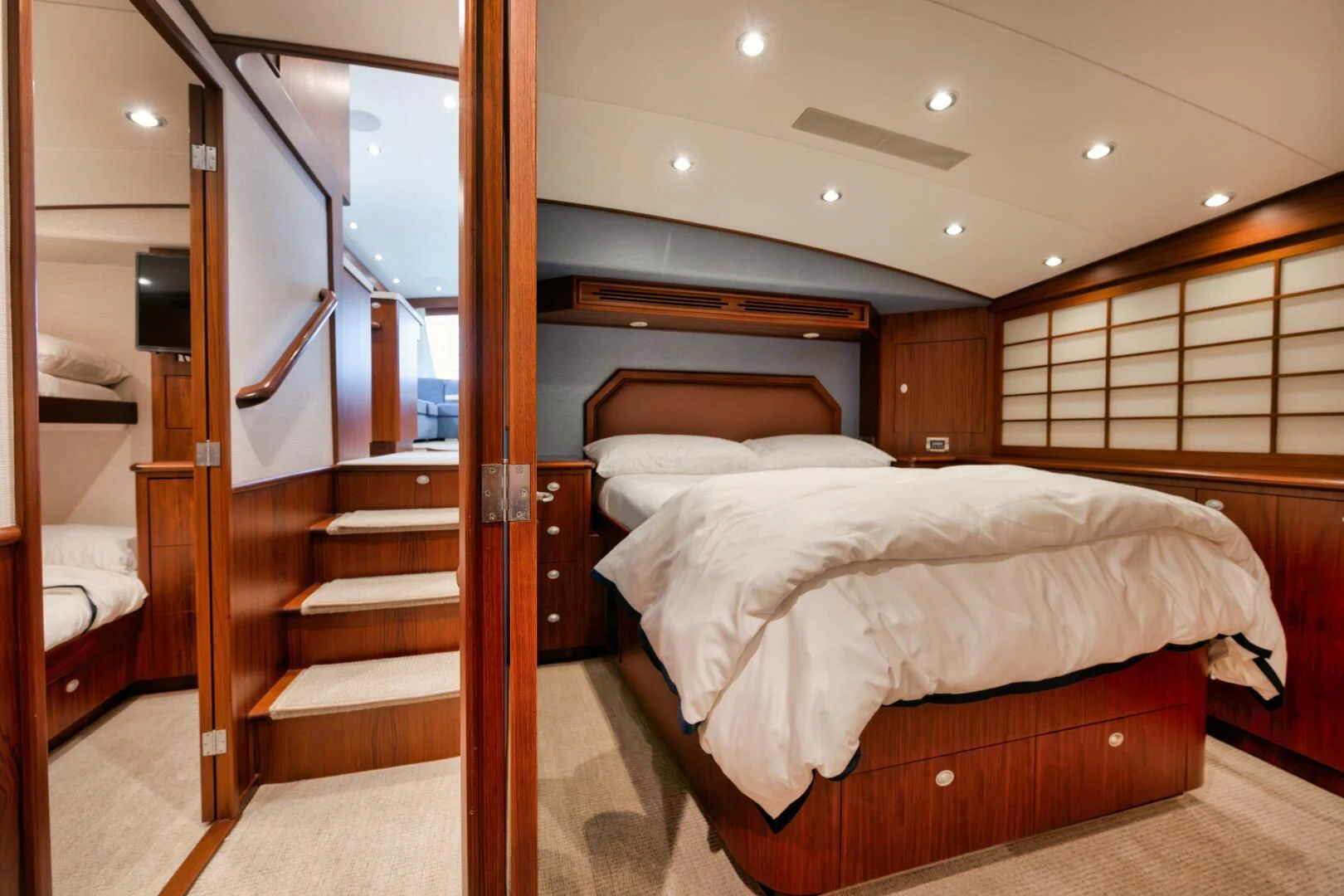 a bedroom with a bed and a wood door aboard W Yacht for Sale