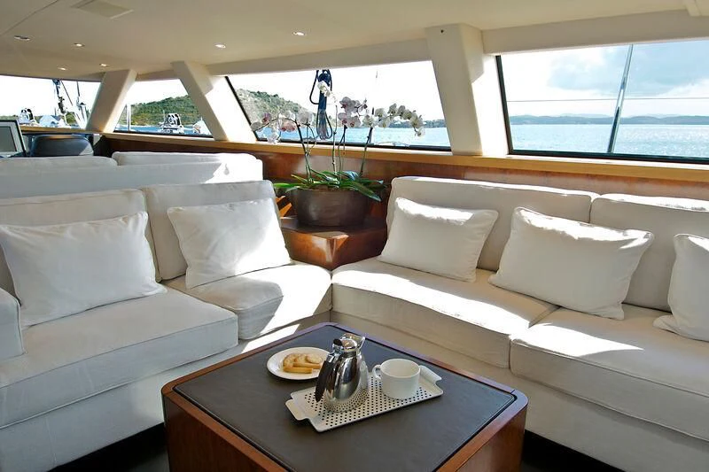 a room with white couches and a coffee table aboard MYSTERE Yacht for Sale