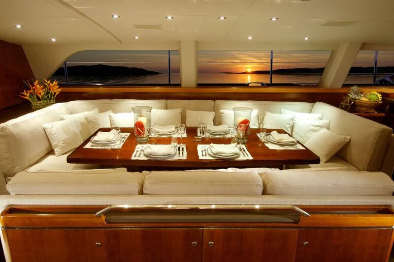 a room with a couch and a table with glasses on it aboard MYSTERE Yacht for Sale