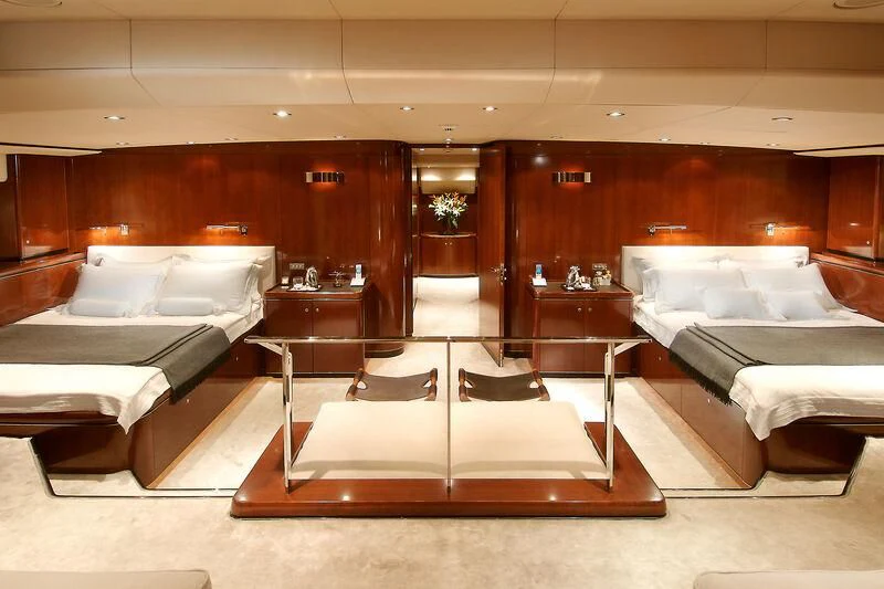 a room with beds and a table aboard MYSTERE Yacht for Sale