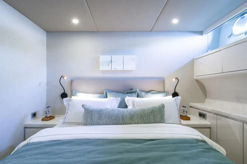 a bed with blue sheets aboard AXELLA Yacht for Sale