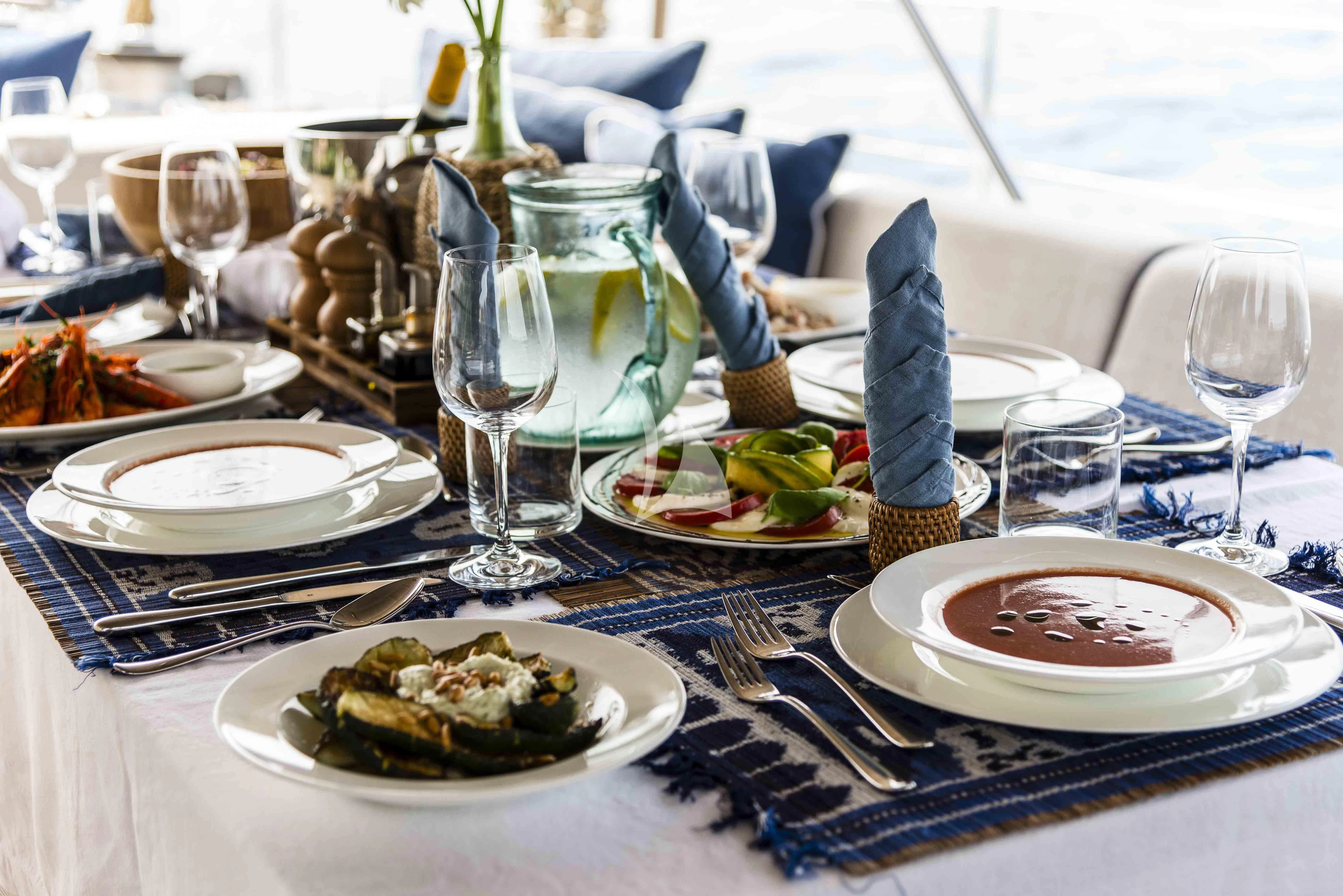 a table with plates and glasses aboard ACAIA Yacht for Sale