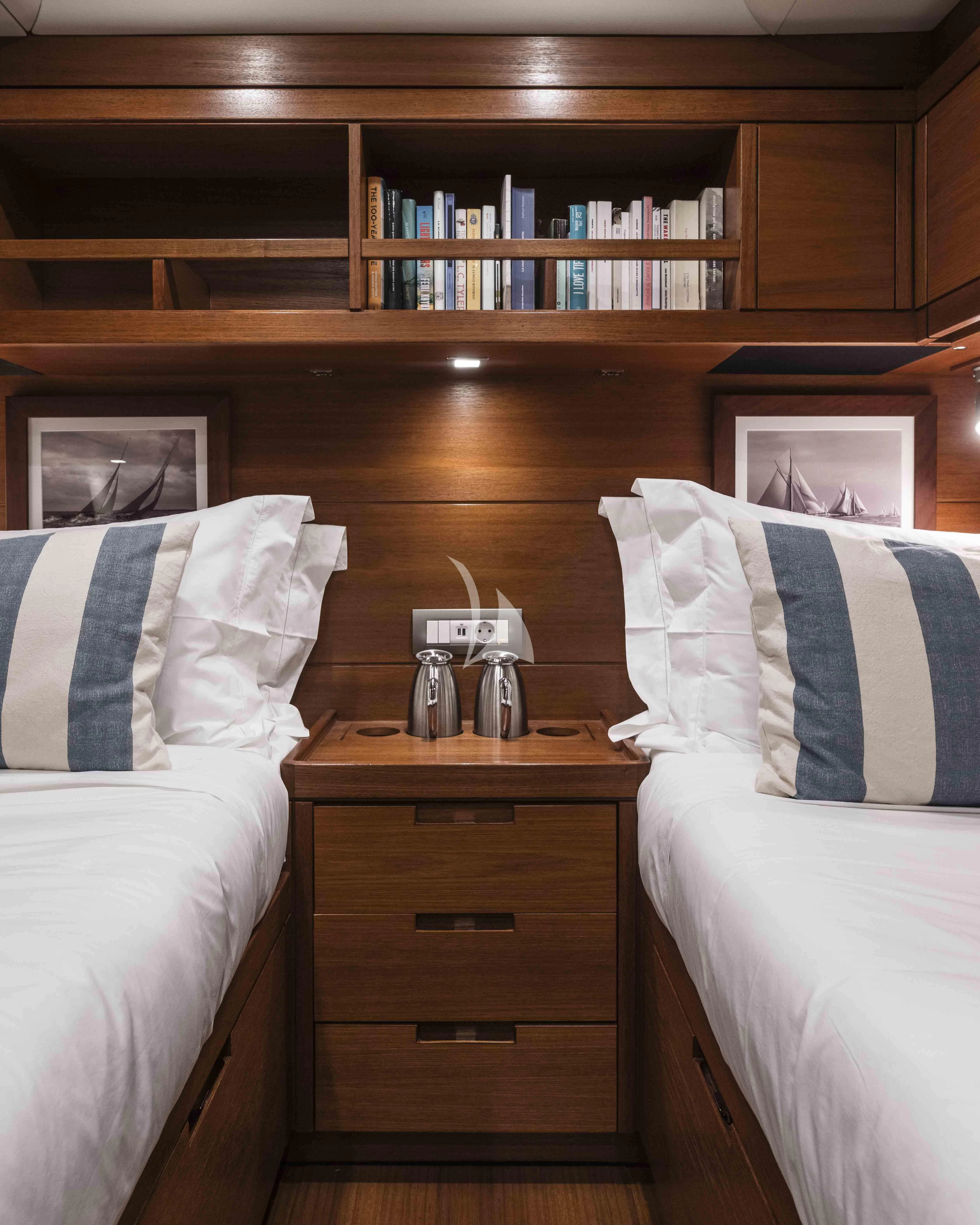 a bed with a bookcase and a shelf with books aboard ACAIA Yacht for Sale