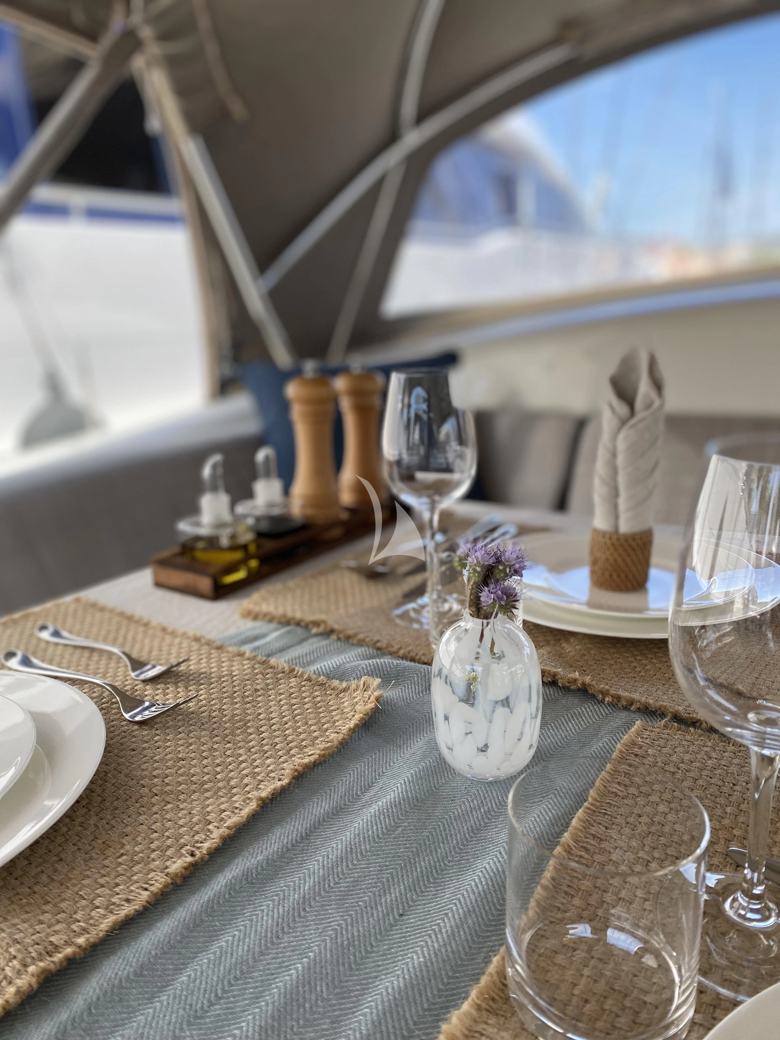 a table with a plate and glasses aboard ACAIA Yacht for Sale