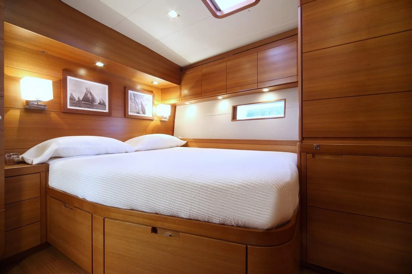 a bedroom with a bed and a wood cabinet aboard ACAIA Yacht for Sale